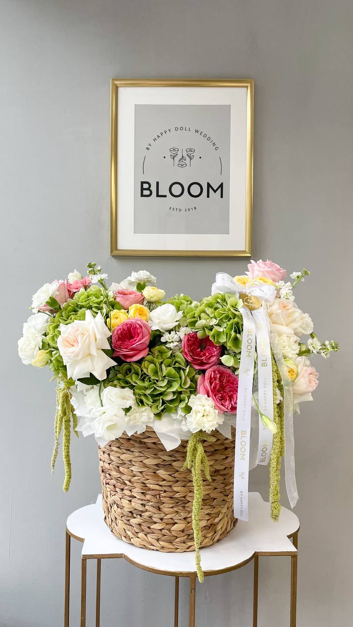 Bloom Garden Basket вторська квіткова композиція в плетеному кошику з трояндами, гортензією та сезонними квітами.