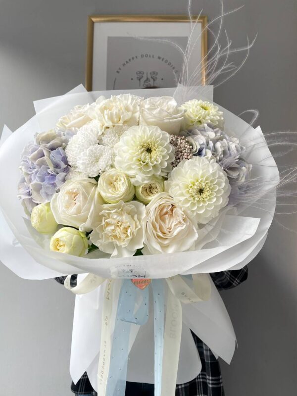 Білий букет із трояндами, жоржинами та гортензією з легким лавандовим відтінком, оформлений стрічками від Bloom by Happy Doll
