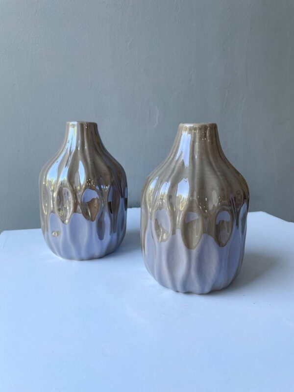 Дві керамічні бежеві вази з глянцевою хвилястою фактурою на світлому фоні