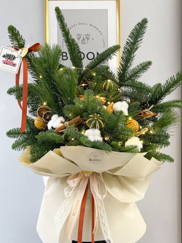 Зимова флористична композиція з хвої, кориці, шишок, бавовни та висушених цитрусів у святковому оформленні.