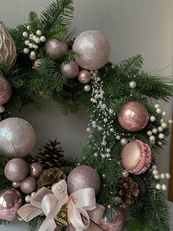 Новорічний вінок із хвої з рожевими кулями, шишками, перлинним декором і стрічками BLOOM.