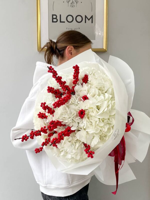 Букет із білої гортензії та червоних ягід у білому пакуванні, зимова святкова композиція.