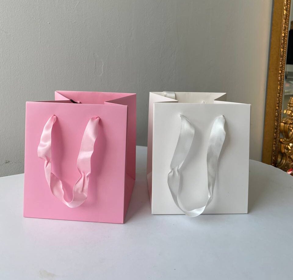 Паперовий подарунковий пакет «CUBY» 1 Однотонні паперові подарункові пакети рожевого та білого кольору з атласними ручками