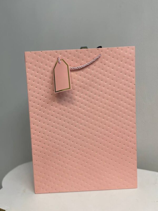 Ніжний рожевий паперовий подарунковий пакет з тисненням у вигляді точок та біркою