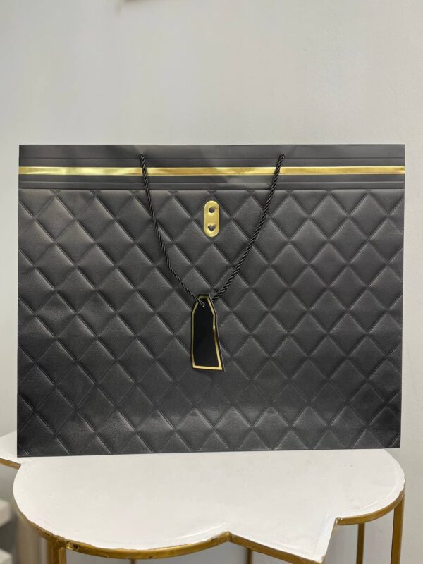 Чорний паперовий подарунковий пакет з ромбоподібним тисненням, золотими акцентами та крученими ручками