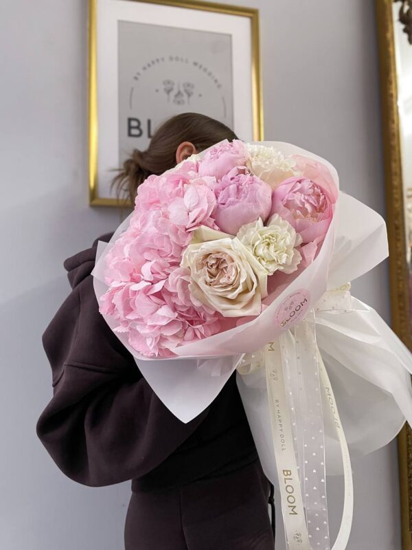 Ніжний букет із рожевої гортензії, півоній та кремових троянд у світлій фірмовій упаковці Bloom