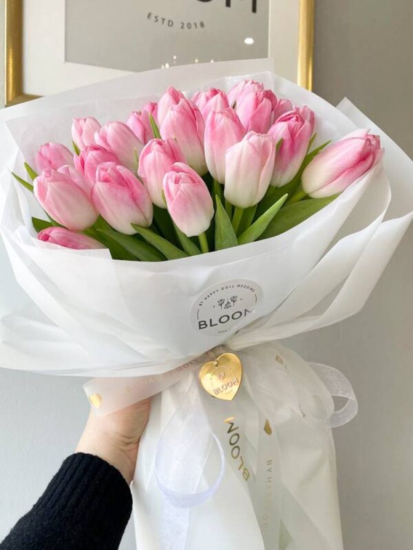 Букет ніжно-рожевих тюльпанів Bloom у білому напівпрозорому пакуванні зі стрічками