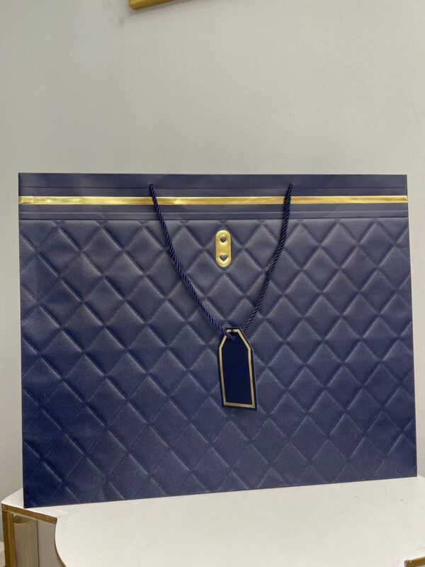 Темно-синій паперовий подарунковий пакет з ромбоподібним тисненням, золотими деталями та крученими ручками