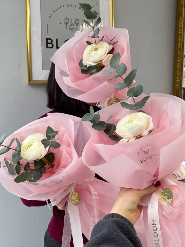 Мінімалістичний букет з кремовим ранункулюсом та евкаліптом у рожевій упаковці Bloom.