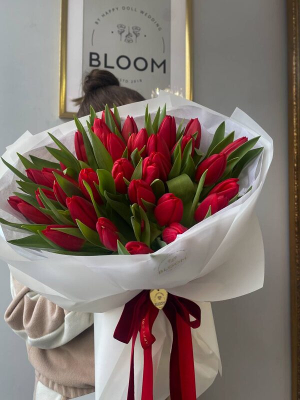 Букет квітів із насичено-червоних тюльпанів у білій упаковці з червоною стрічкою Bloom.