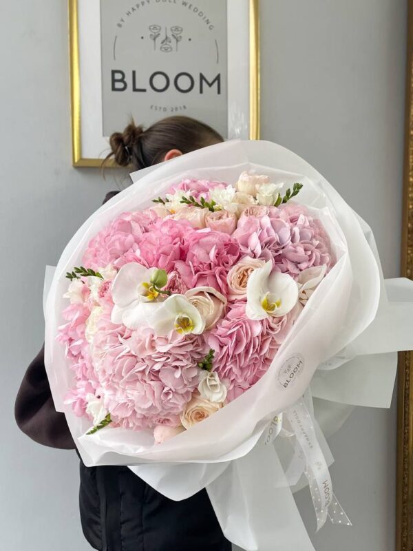 Романтичний букет квітів з рожевою гортензією, садовими трояндами та білими орхідеями у білій упаковці Bloom.
