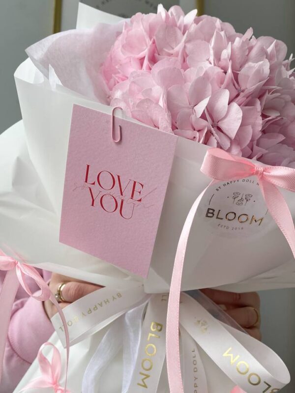 Букет квітів з рожевої гортензії у білій упаковці Bloom з рожевою стрічкою