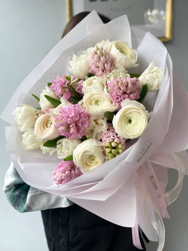 Ніжний букет квітів з білими ранункулюсами та рожевими гіацинтами у білій упаковці Bloom