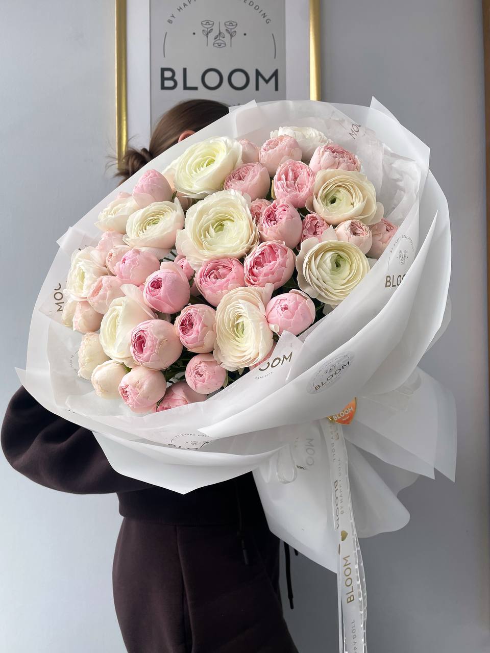 Букет квітів «Усі квіти світу для тебе» 1 Пастельний букет квітів з рожевих троянд та кремових ранункулюсів у білій упаковці Bloom