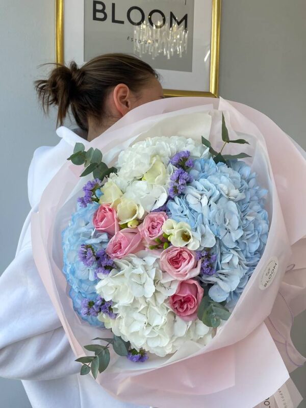 Букет з блакитною та білою гортензією і рожевими трояндами у світлій упаковці Bloom.