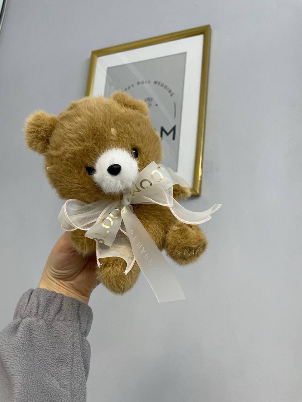 Карамельний плюшевий ведмедик 1 Маленький плюшевий ведмедик карамельного кольору з бантом Bloom у руках