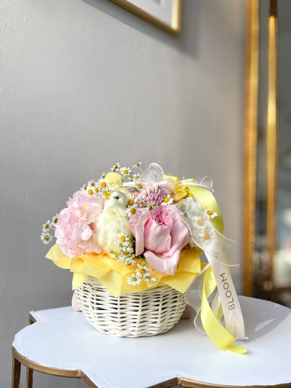 Весняна композиція у кошику з гортензією, трояндами, ромашками та декоративним цыплёнком Bloom у жовто-рожевих відтінках.