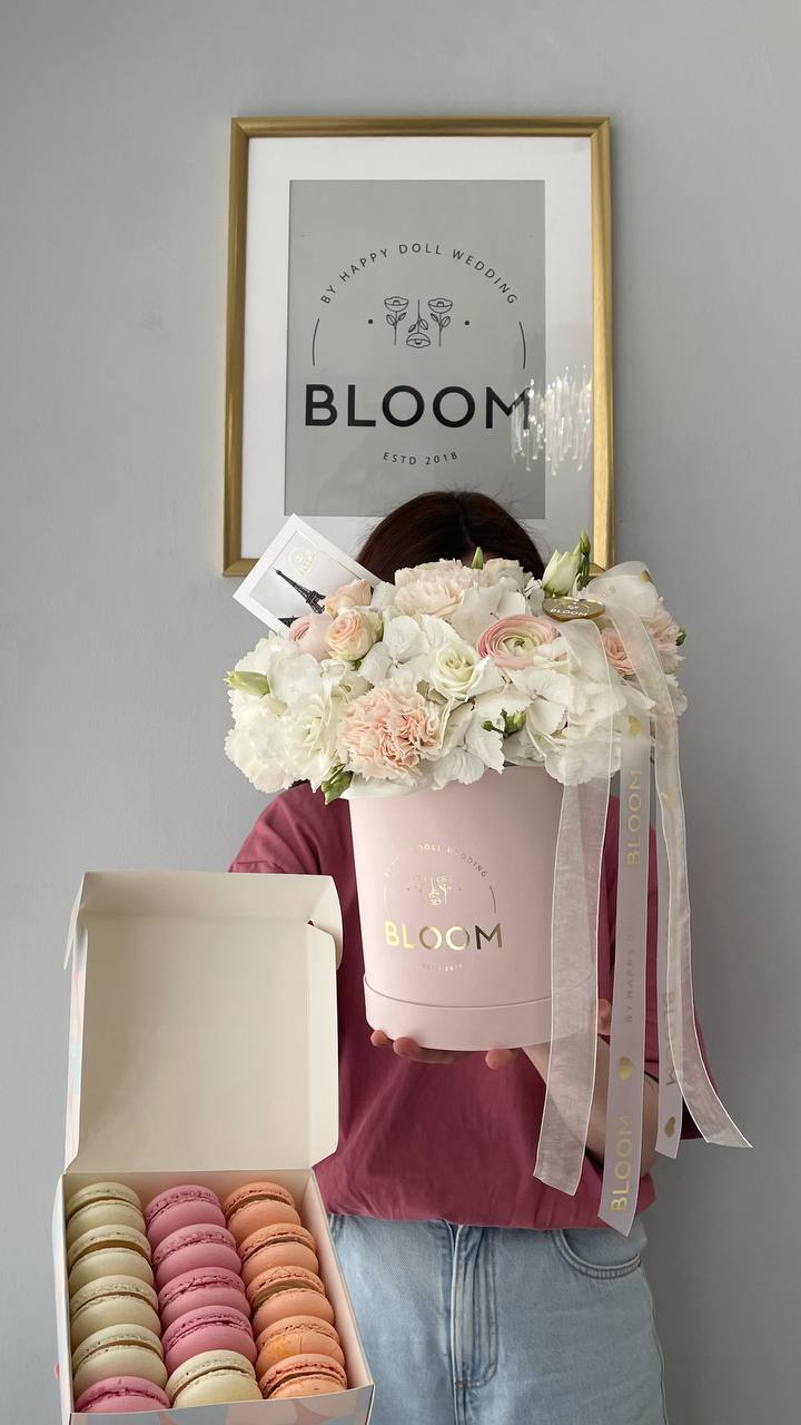 Квіткова композиція з макаронс «Vanilla Bloom» 1 Квіткова композиція Bloom у рожевій коробці з білими квітами та набором макаронс.