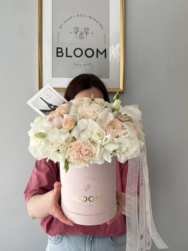 Квіткова композиція Bloom у рожевій коробці з білими квітами та набором макаронс.